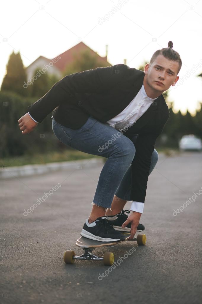 Image of a man with longboard going on road