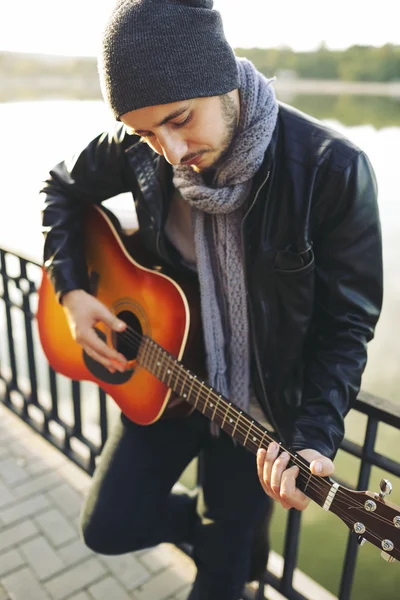 Νεαρός άνδρας παίζει στην κιθάρα στη λίμνη — Φωτογραφία Αρχείου