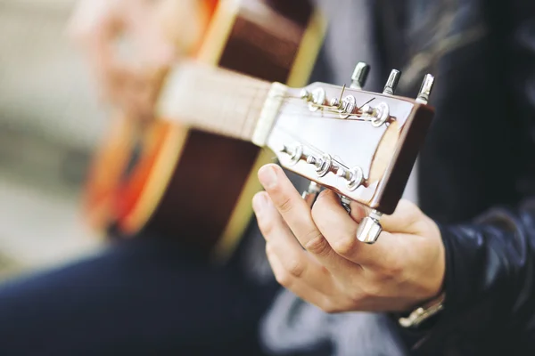 Jonge aantrekkelijke straat kunstenaar met zijn gitaar — Stockfoto