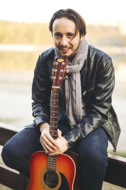 Genç adam gitar gölde oynamak