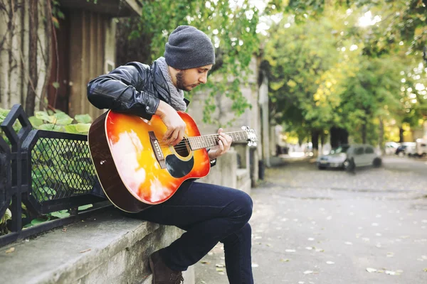 Young musician with guitar in city — Stock Photo, Image