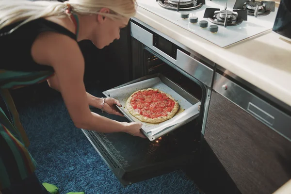 Femme cuisine pizza à la cuisine — Photo