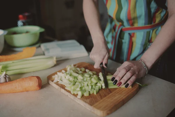 Mujer joven cortando verduras — Foto de Stock