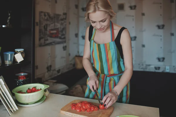 Jeune femme tranchant des tomates — Photo