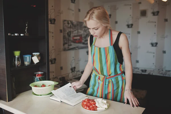 Молода жінка дивиться в книгу рецептів — стокове фото