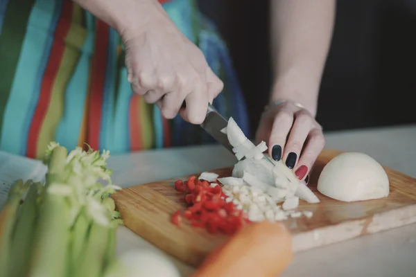 Mujer joven cortando verduras — Foto de Stock