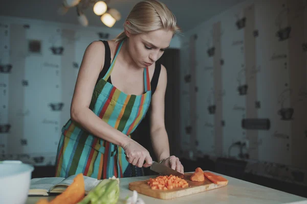 Jonge vrouw snijden groenten — Stockfoto