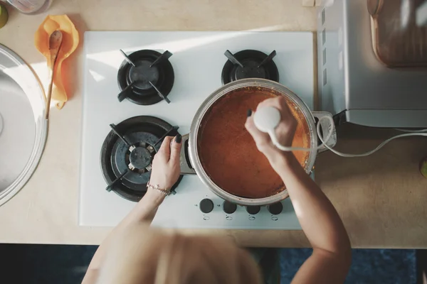 Jeune femme préparant la soupe de citrouille — Photo