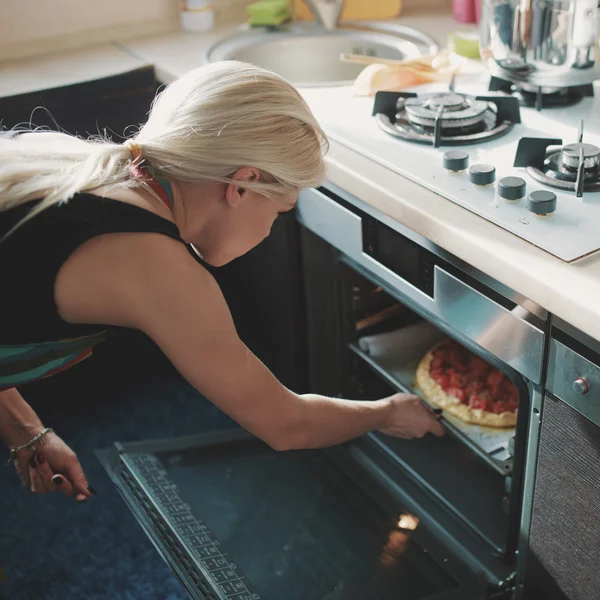 Жінка готує піцу на кухні — стокове фото
