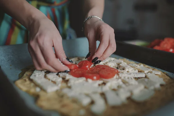 Женщина готовит пиццу на кухне — стоковое фото