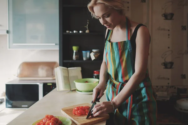 Jovem mulher cortando tomates — Fotografia de Stock