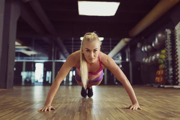 Entrenamiento de mujer atlética fuerte y hermosa en el gimnasio — Foto de Stock