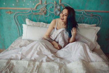 Kadın uyandıktan sonra yatakta geriniyor.