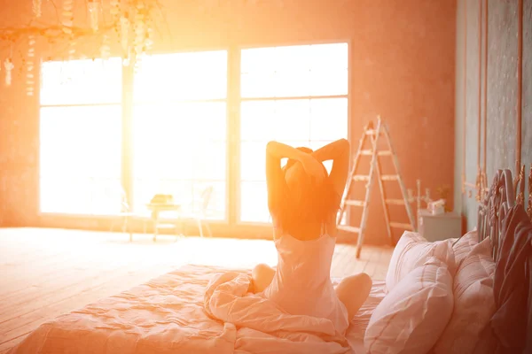 Mujer estirándose en la cama después de despertar —  Fotos de Stock