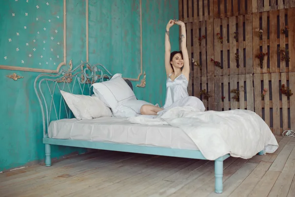 Женщина растягивается в постели после пробуждения — стоковое фото