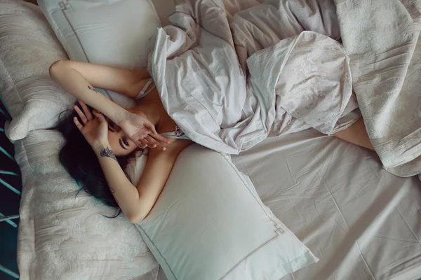 Nő nyújtózkodik az ágyban ébredés után — Stock Fotó