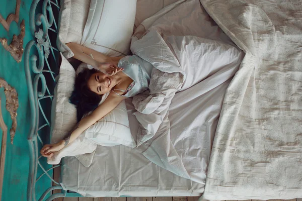 Mujer estirándose en la cama después de despertar —  Fotos de Stock