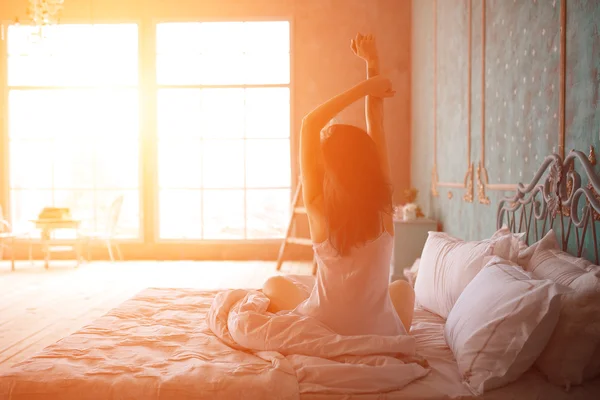 Mujer estirándose en la cama después de despertar —  Fotos de Stock