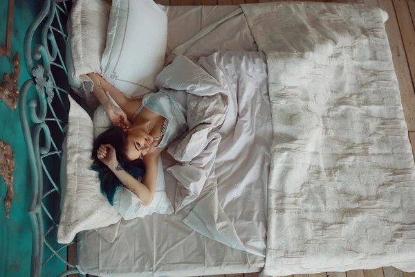 Žena protahuje v posteli po probuzení — Stock fotografie
