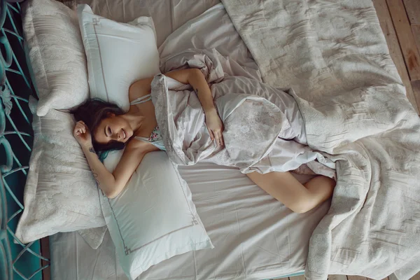 Mujer estirándose en la cama después de despertar —  Fotos de Stock