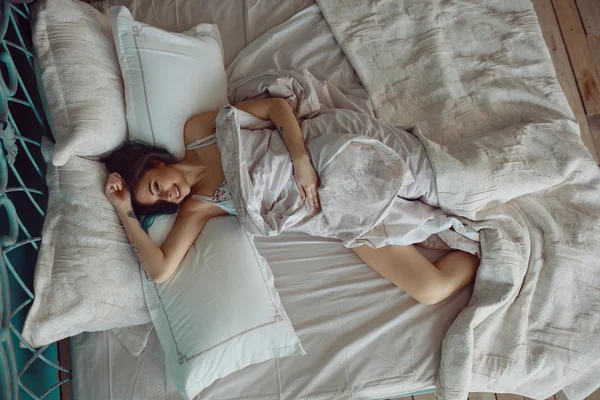 Mulher esticando na cama depois de acordar — Fotografia de Stock