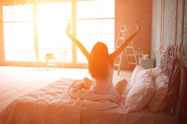 Mujer estirándose en la cama después de despertar —  Fotos de Stock