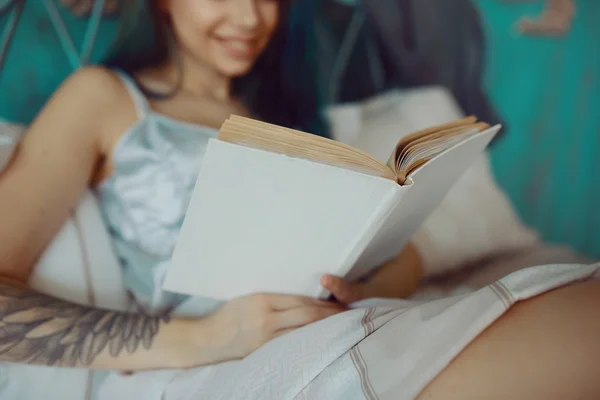 Улыбающаяся возбужденная женщина читает книгу по утрам — стоковое фото