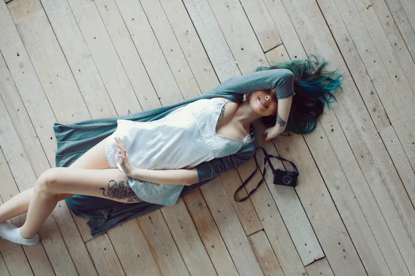 Hermosa mujer casual joven despreocupada acostada en el suelo de madera — Foto de Stock