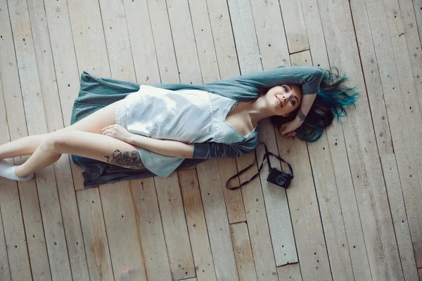 Bella donna casual giovane spensierata sdraiato sul pavimento in legno — 图库照片