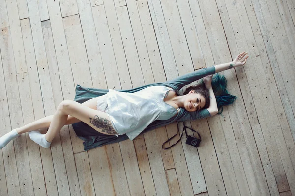 Vacker sorglös ung casual kvinna liggande på trägolv — Stockfoto