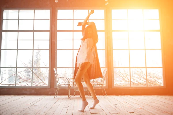 Atractiva joven bailando cerca de enormes maravillas en su apartamento —  Fotos de Stock
