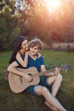 Bahçedeki çimlerin üzerine oturan Romantik Çift