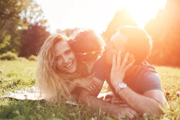 Glückliche junge Familie verbringt Zeit zusammen draußen in der grünen Natur. — Stockfoto