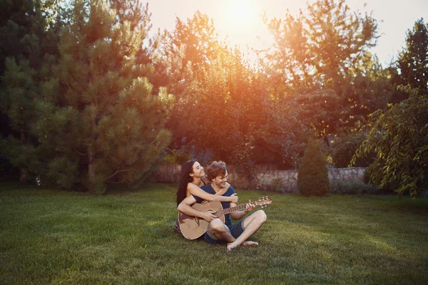 Romantic couple sitting on the grass in the garden — Stock Photo, Image