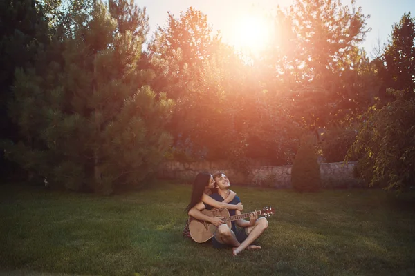Romantic couple sitting on the grass in the garden — Stock Photo, Image