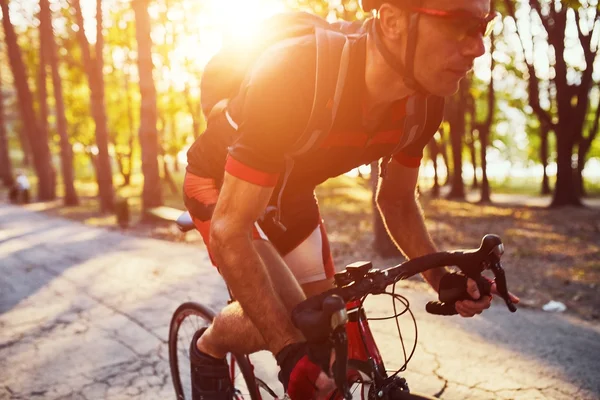 Ung man cyklar väg cykel på kvällen — Stockfoto