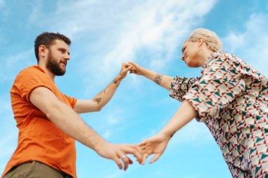 Gökyüzü arka planındaki mutlu çift