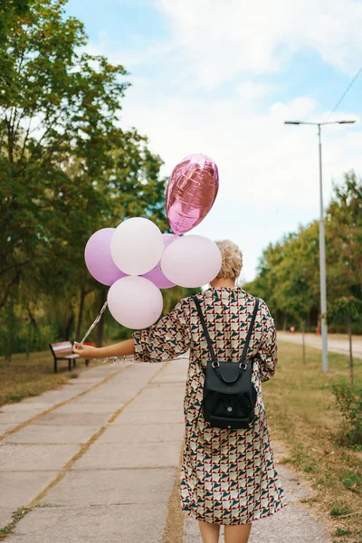Blond kvinna med rosa ballonger — Stockfoto