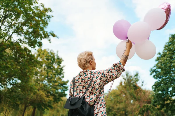 Femme blonde avec des ballons roses — Photo