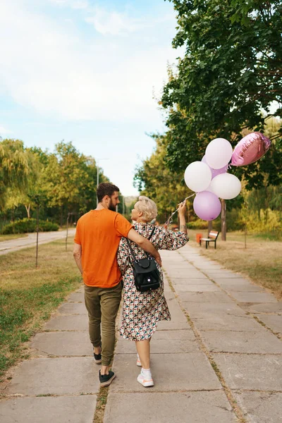 Femme blonde et homme avec des ballons roses — Photo