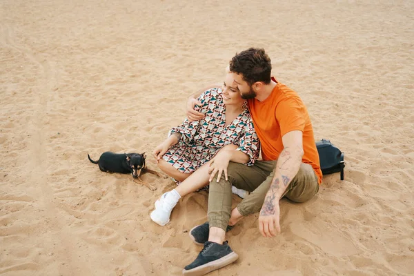 Lovely couple enjoy each other sitting on sand — Stock Photo, Image