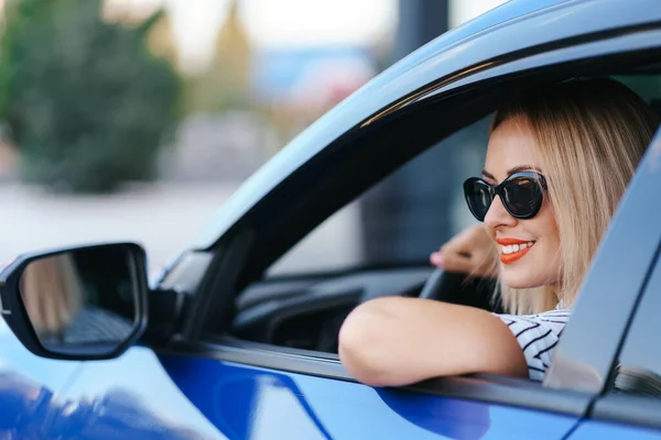 Femme en lunettes de soleil conduisant une voiture — Photo