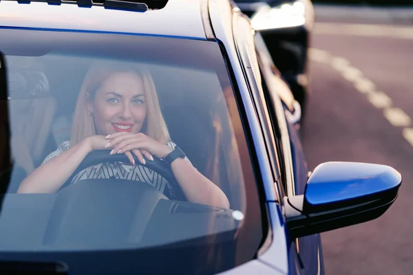 Femme conduisant une voiture, vue par la fenêtre avant — Photo