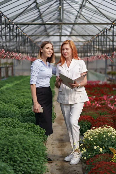 温室を訪問している間に会話をしている2人のビジネス女性 — ストック写真