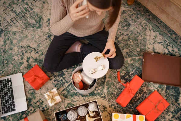 Mujer hablar por teléfono mientras está sentada entre regalos para su familia y amigos — Foto de Stock