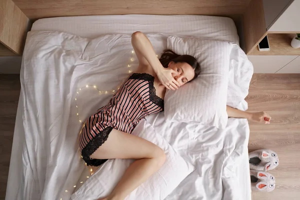 Caucásica mujer estirándose en la cama después de despertar —  Fotos de Stock