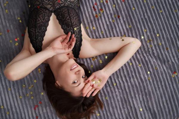 PRETTY femme couché dans le lit avec confettis — Photo