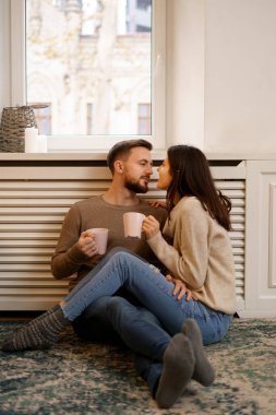 Romantik mutlu genç çift evde gülümseyerek tatilin tadını çıkarıyor.