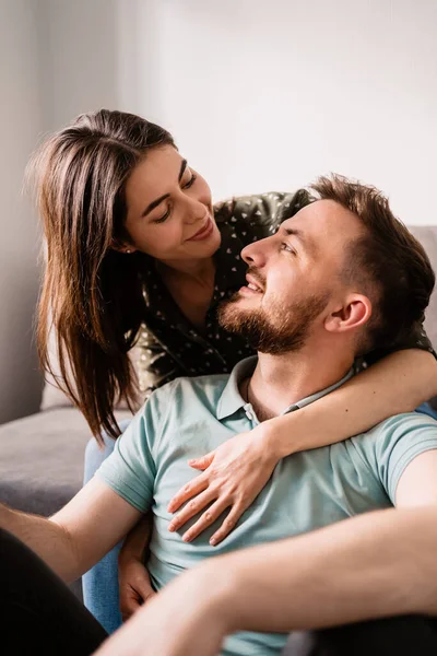 Retrato de hombre y mujer sonriéndose en el sofá — Foto de Stock