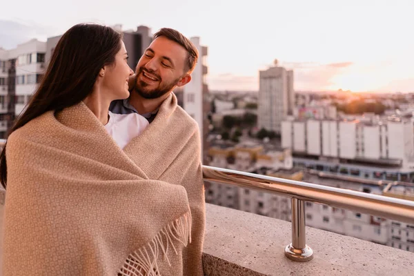 Homem e mulher na varanda ao pôr do sol na cidade — Fotografia de Stock